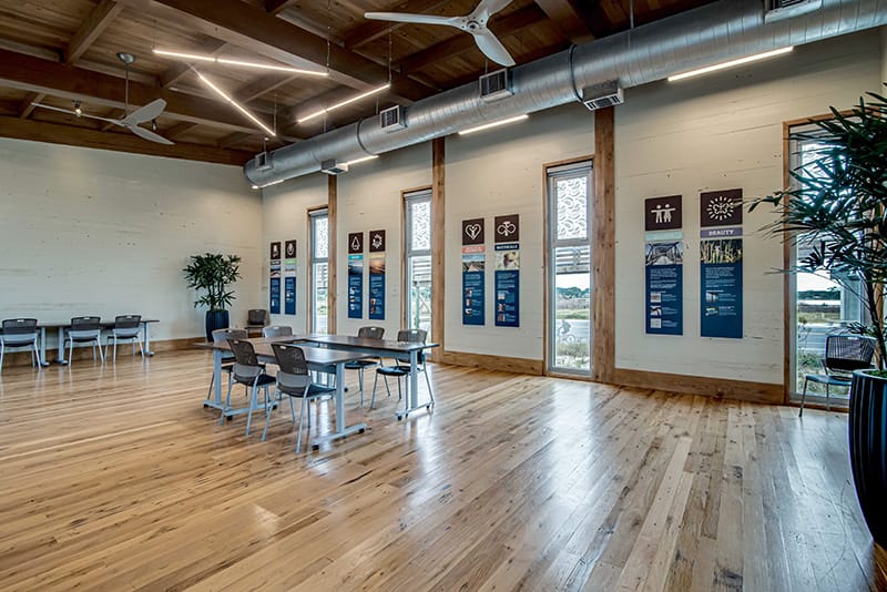 Modern meeting room with tables, chairs, and informational posters on the walls