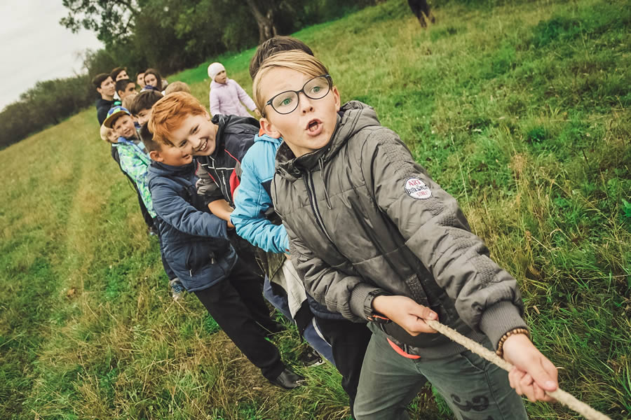 Children playing tug of war in a grassy field