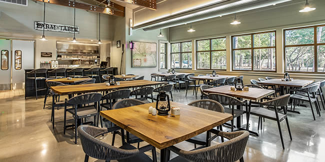 Interior of a spacious modern café with empty tables and a visible counter
